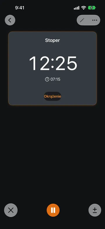 Działający Stoper z odczytem 12:25, godziną uruchomienia 07:15 pod odczytem i przyciskiem Okrążenie. U dołu ekranu znajdują się przycisk X, pomarańczowy przycisk Wstrzymaj i przycisk plus-minus.